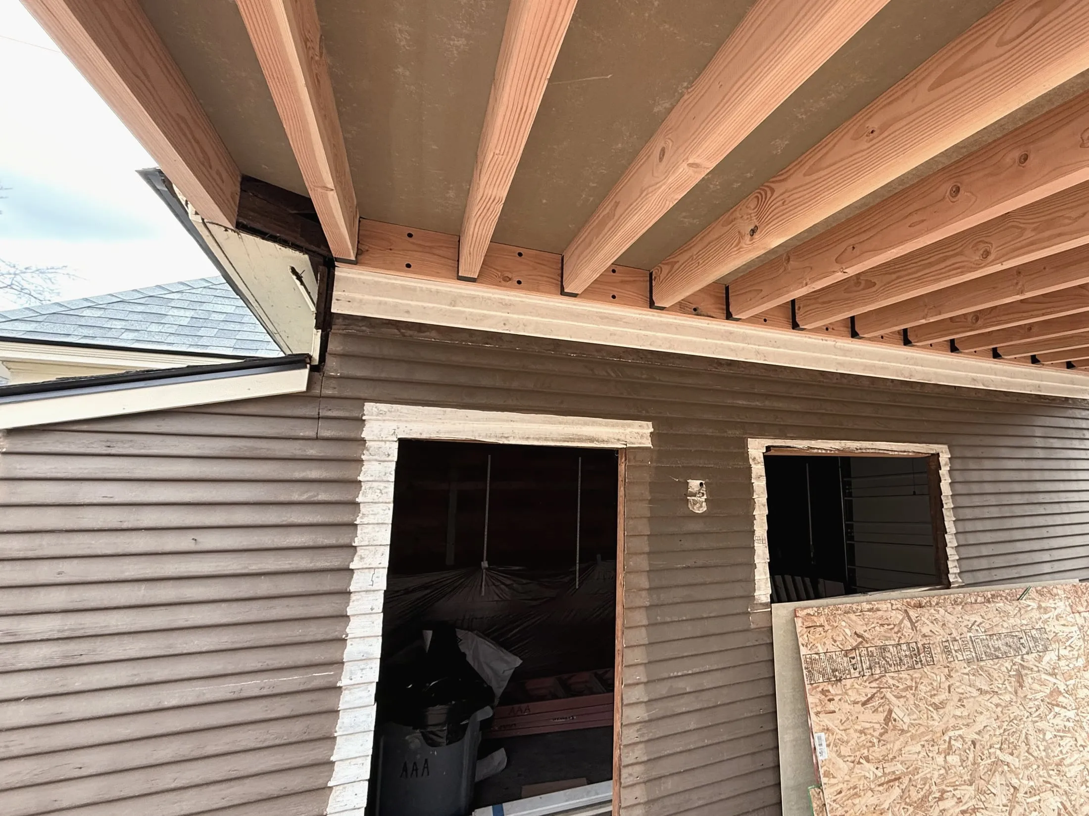 The ledger board and joist hangers against the existing garage wall