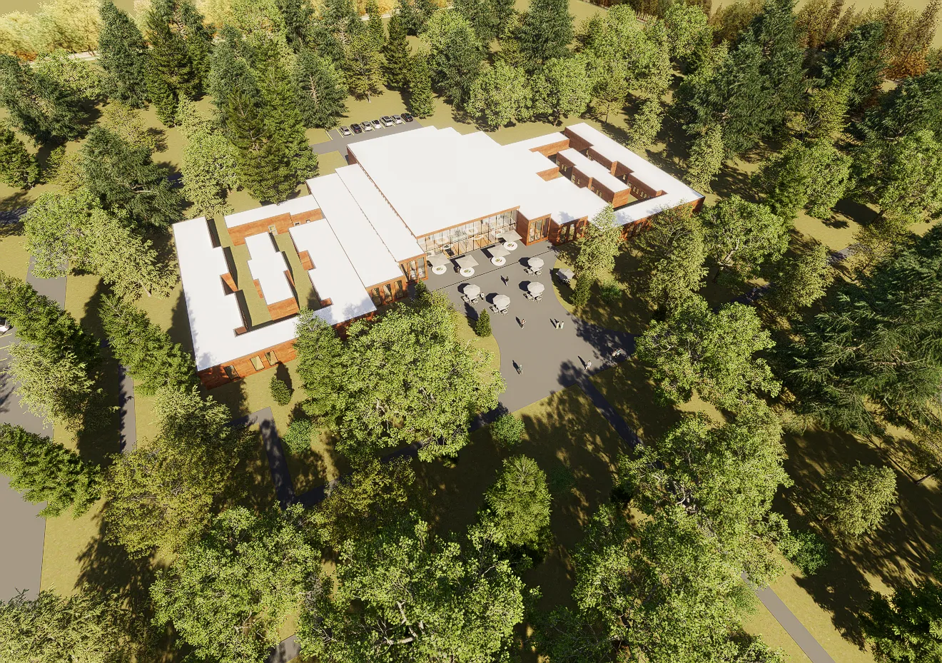 Aerial view — the corten roofs of the refuge low among the trees, the pond beside them